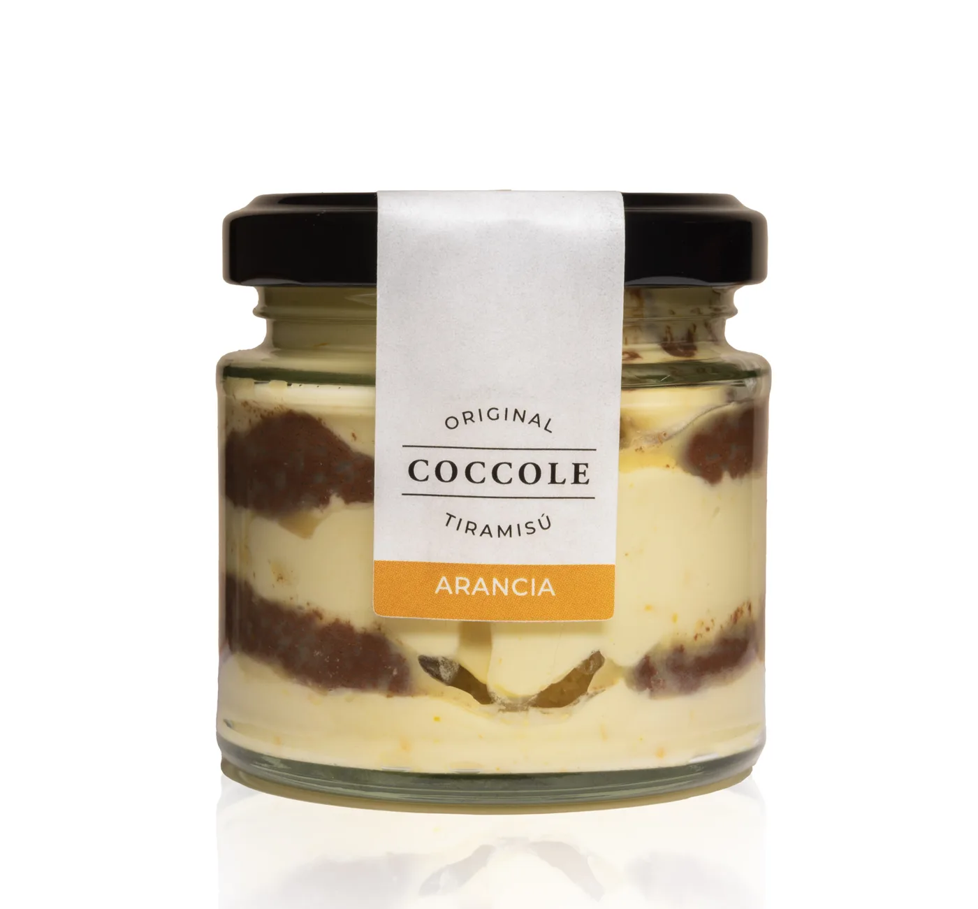 A glass jar of Coccole tiramisù with a black lid and an orange label reading Arancia, showing layers of cream and sponge