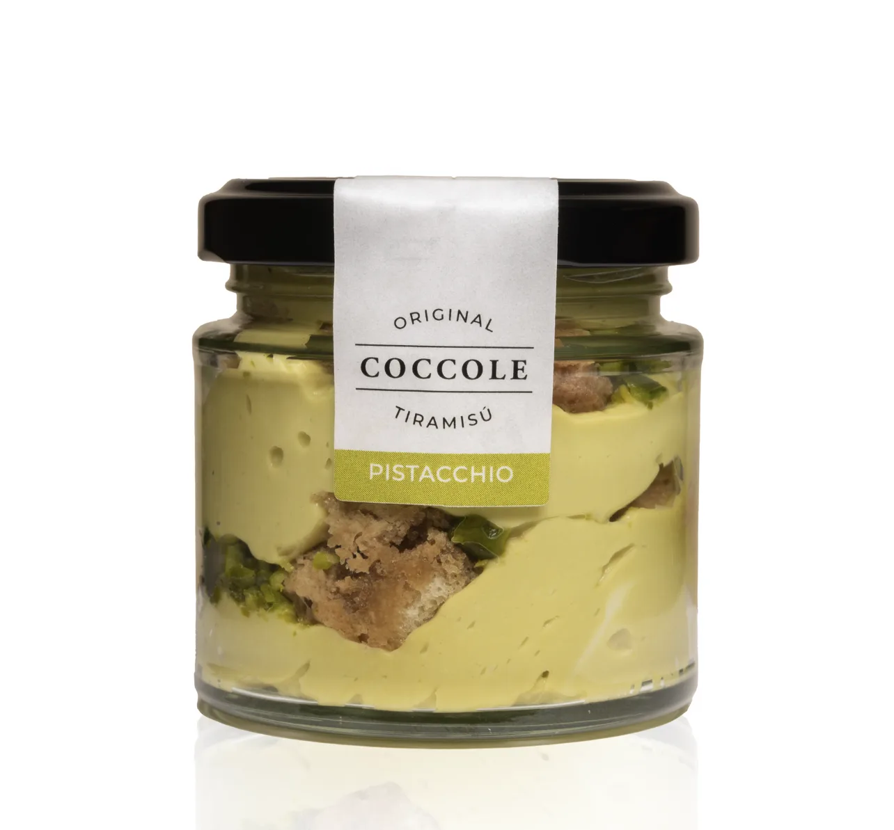 A glass jar of Coccole pistachio tiramisù with a green Pistacchio label, showing pale green cream, sponge and chopped pistachios